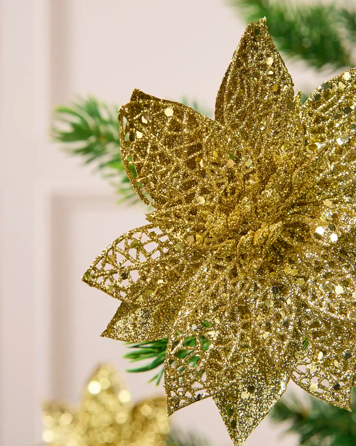 Detailed view of the Gold glitter artificial poinsettia flower, highlighting its layered petals and shimmering finish.
