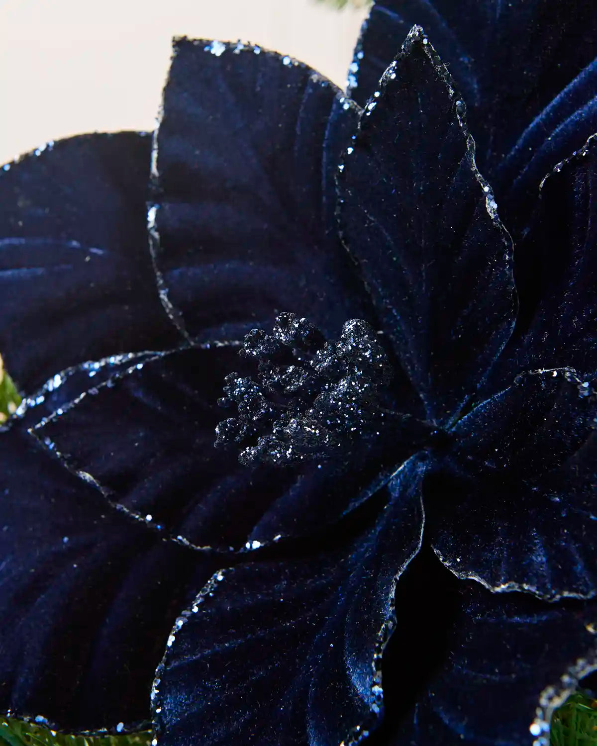 Detailed view of the Navy  velvet poinsettia’s glittered center and textured petals
