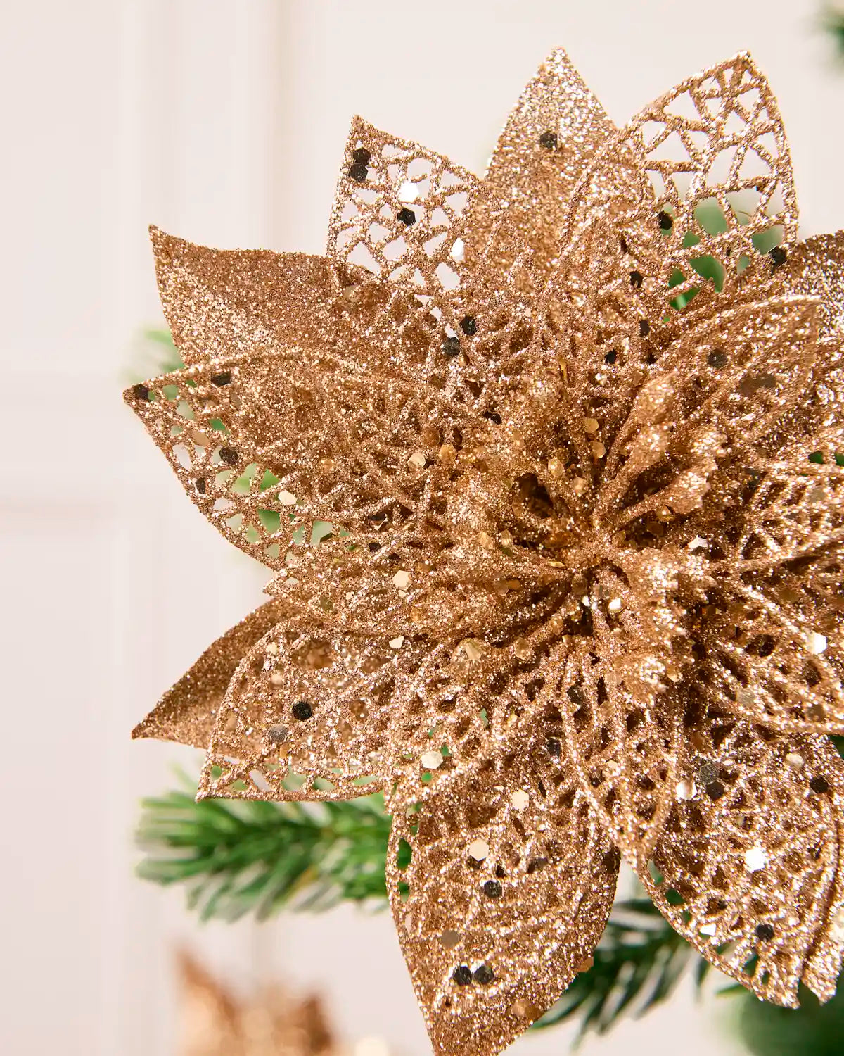 Detailed view of the Rose Gold glitter artificial poinsettia flower, highlighting its layered petals and shimmering finish
