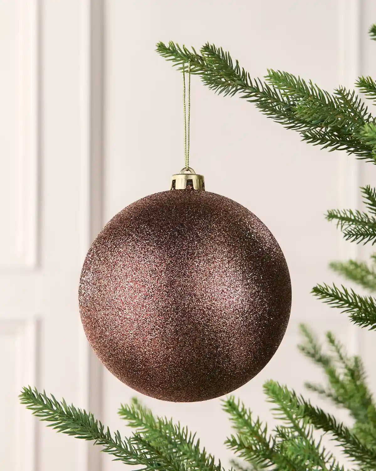 Espresso 15 cm oversized Glitter shatterproof bauble hanging on a Christmas tree with a gold cap and matching string.
