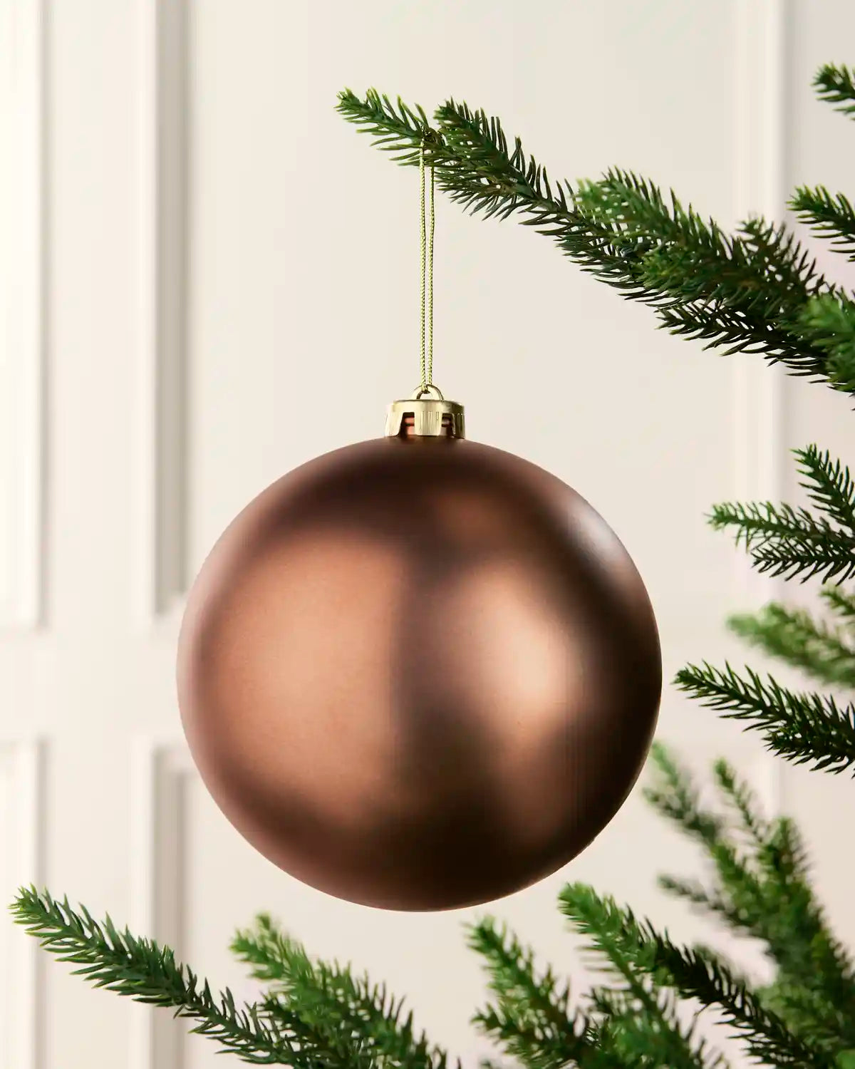 Espresso 15 cm oversized Matt shatterproof bauble hanging on a Christmas tree with a gold cap and matching string.
