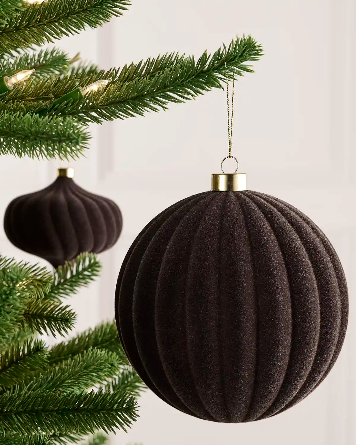 Espresso 15 cm oversized velvet Ribbed bauble displayed on a Christmas tree with coordinating ornaments.
