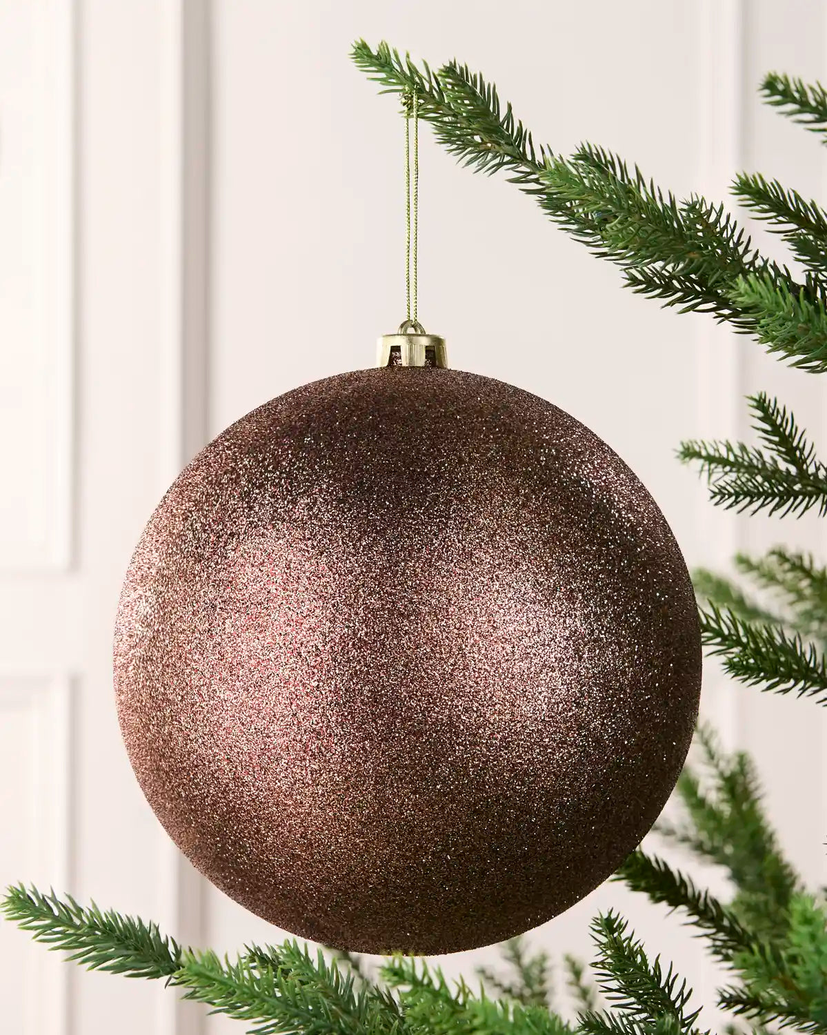 Espresso 20 cm oversized Glitter shatterproof bauble hanging on a Christmas tree with a gold cap and matching string.
