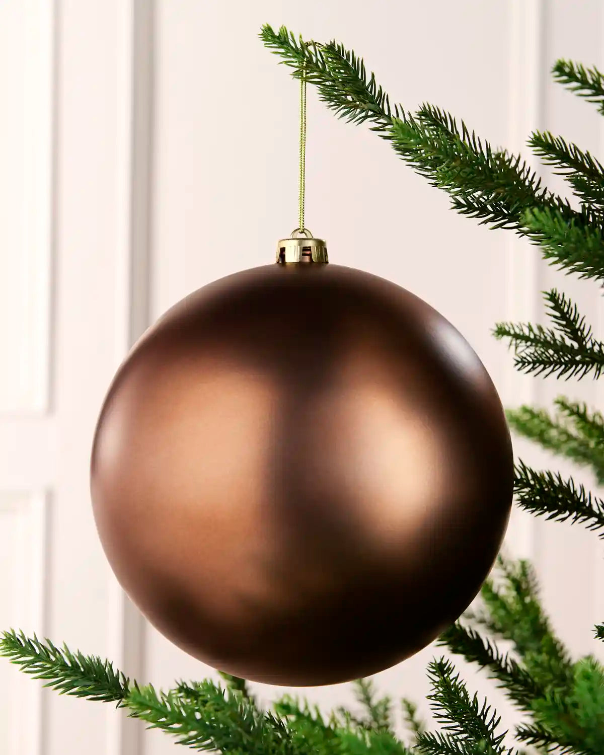 Espresso 20 cm oversized Matt shatterproof bauble hanging on a Christmas tree with a gold cap and matching string.
