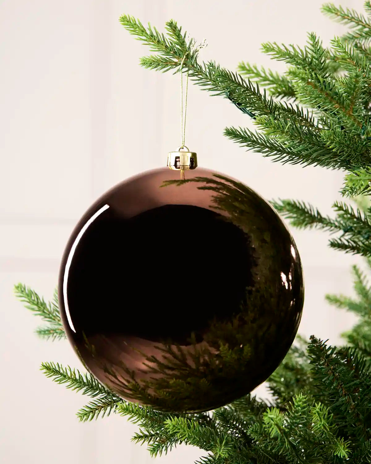 Espresso 20 cm oversized Shiny shatterproof bauble hanging on a Christmas tree with a gold cap and matching string.
