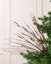 Espresso Glitter Wispy Spray with long, slender glitter-covered stems arranged in a fan shape on a Christmas tree
