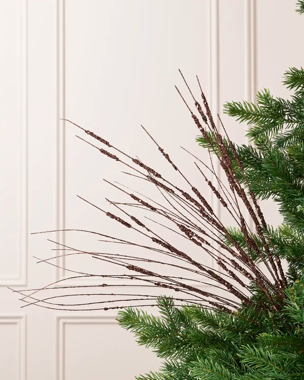 Espresso Glitter Wispy Spray with long, slender glitter-covered stems arranged in a fan shape on a Christmas tree
