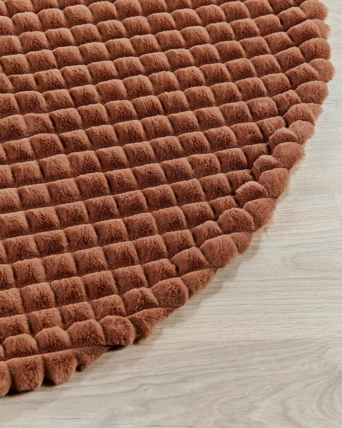 Close-up of the edge of the espresso faux fur diamond tree skirt edge on light wooden flooring, highlighting the soft texture