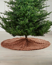 Full image of the espresso faux fur diamond tree skirt on light wooden flooring underneath green Christmas tree