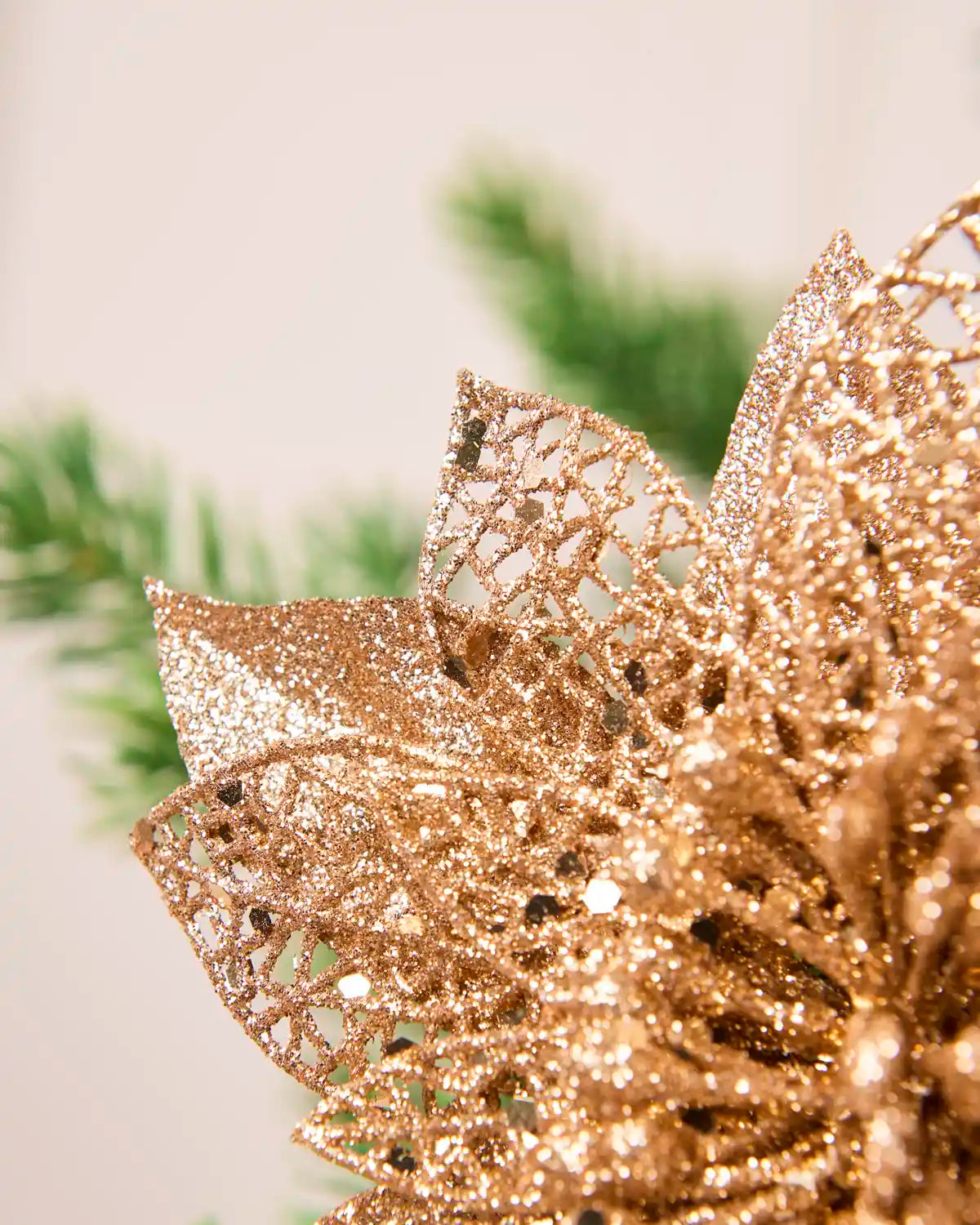 Extreme close-up of Rose Gold glitter poinsettia petals with an open, decorative glittered texture.