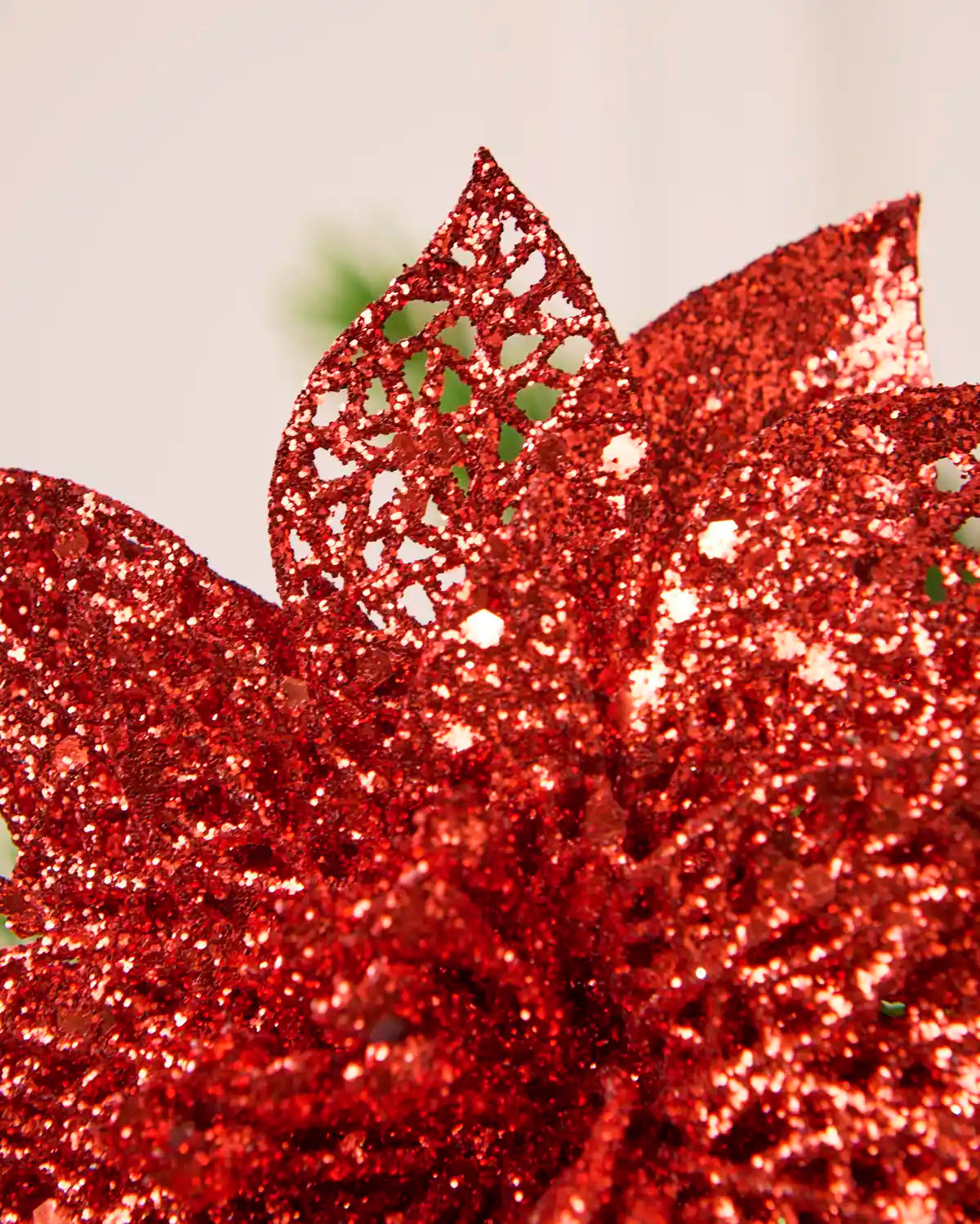 Extreme close-up of red glitter poinsettia petals with an open, decorative glittered texture.