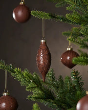 Five Espresso Christmas baubles hanging on a tree with a dark background