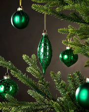 Five Green Christmas baubles on a tree against a dark background