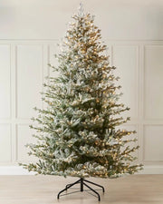 Frosted 9ft Christmas tree against cream panel wall on a wooden floor