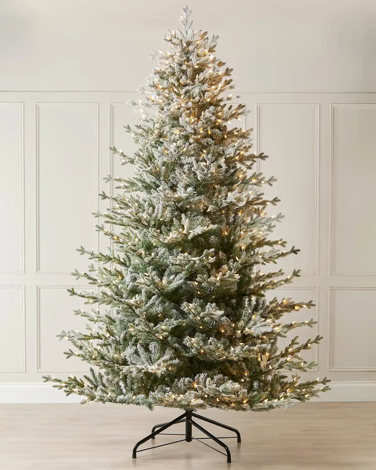 Frosted 9ft Christmas tree against cream panel wall on a wooden floor