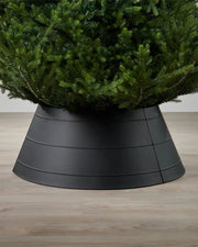 Full image of black metal tree collar on light wood flooring