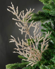 Full image of gold beaded crystal spray attached to Christmas tree in front of grey wall background