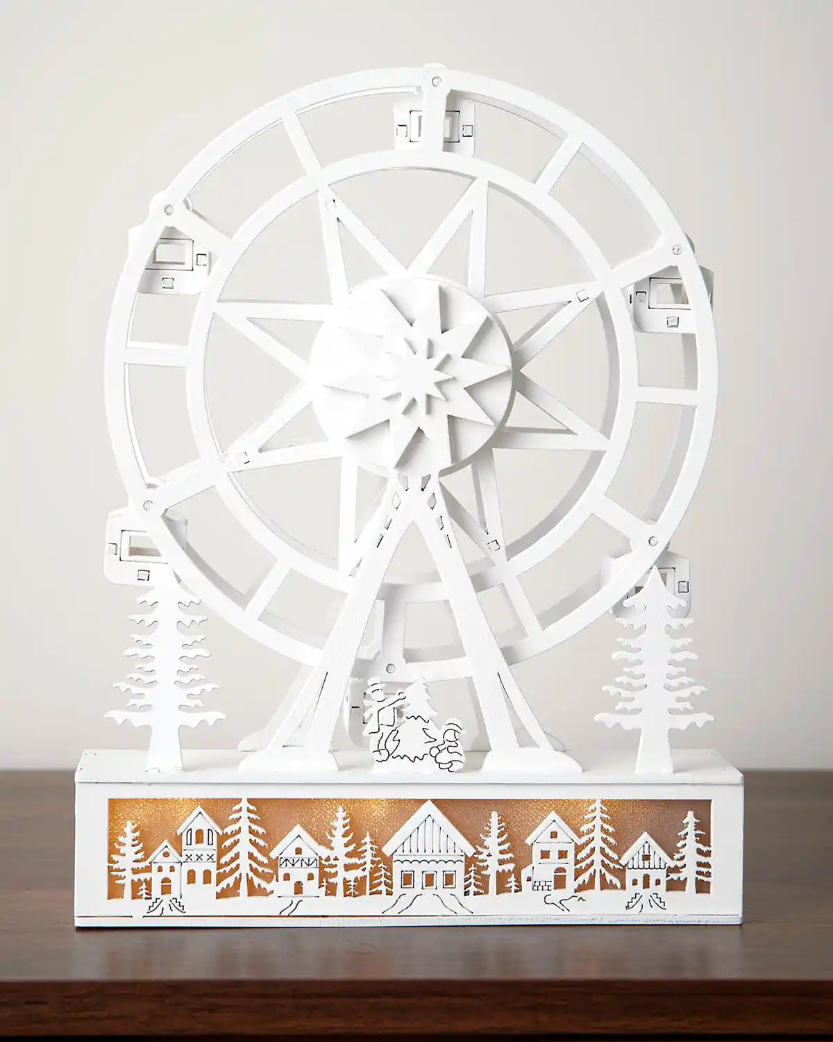 Full image of pre-lit white animated ferris wheel with warm white light on a dark wood surface with a white background