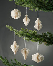 Full-range image of 10cm off-white paper decorations hanging from the Christmas tree in front of grey wall background