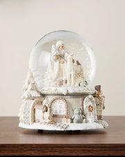 Full image of Santa snow globe on dark wood surface in front of white wall background