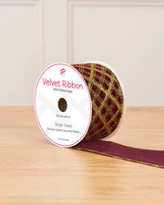 Glitter Diamond Velvet Wire Edge Ribbon in Burgundy with gold detailing on a wooden surface 
