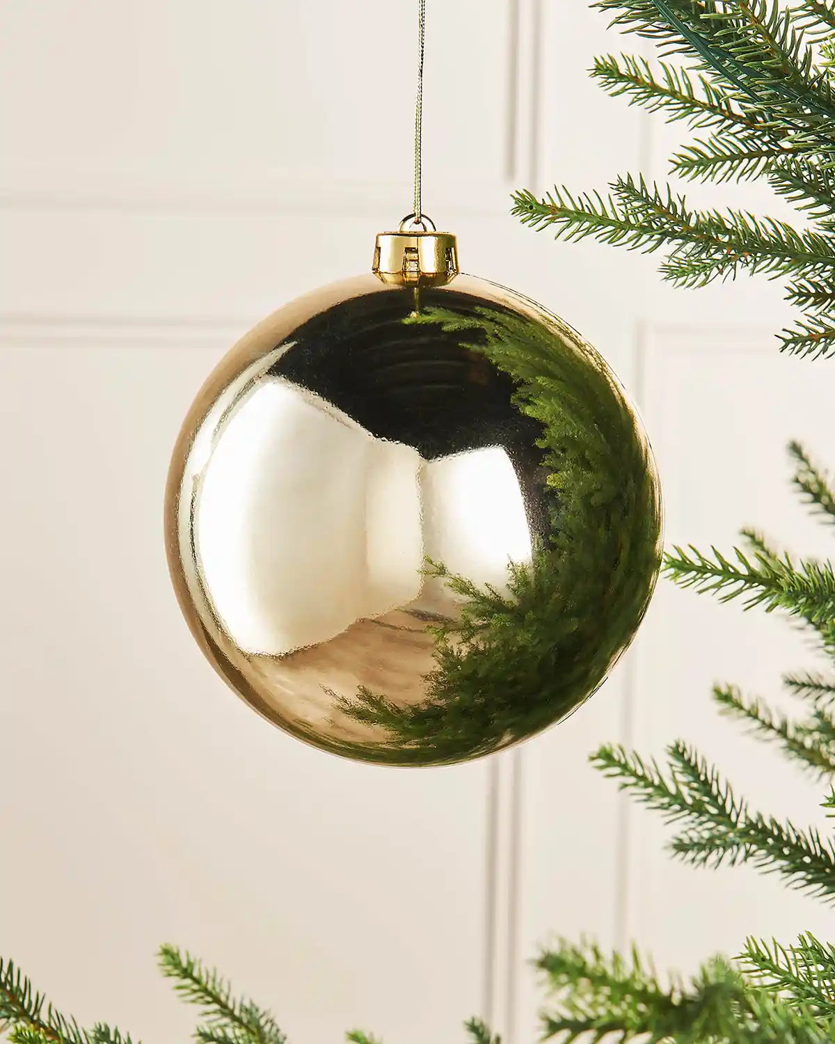 Gloss gold 15m oversized bauble on a Christmas tree branch 