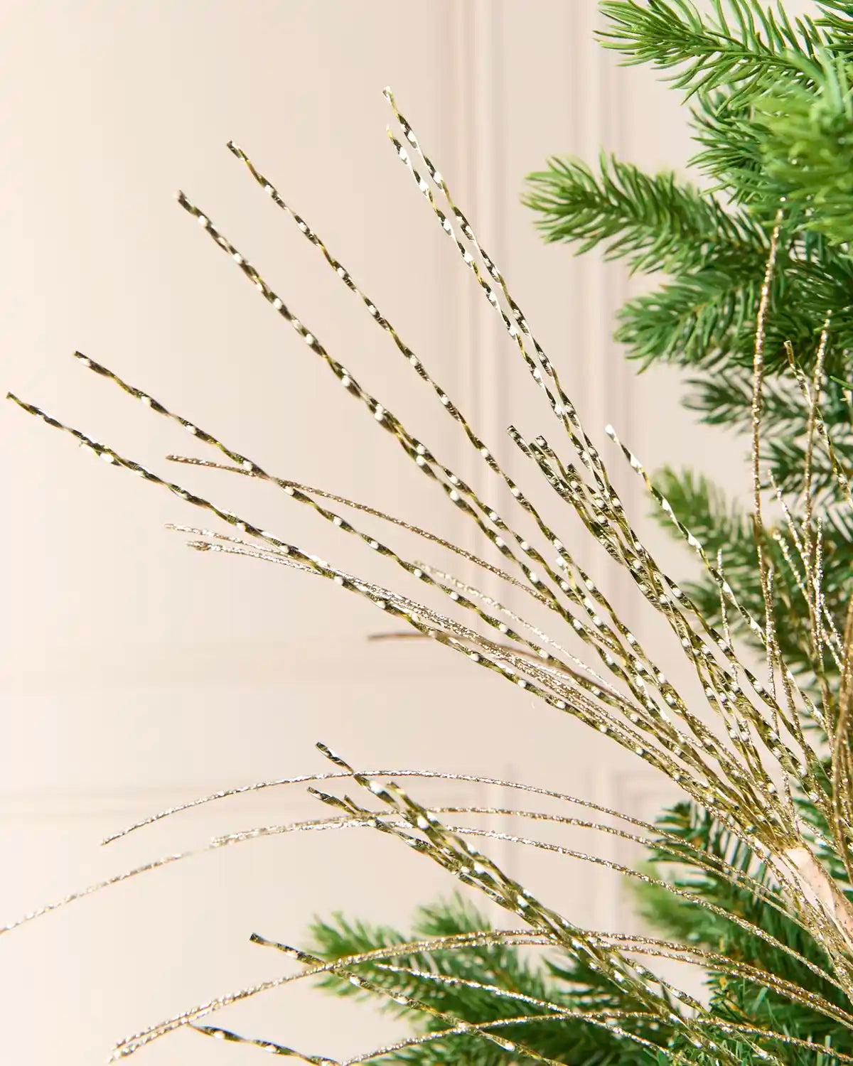 Gold Glitter Fountain Christmas Tree Spray with long, slender twisted strands extending upward and outward from the center of a Christmas tree