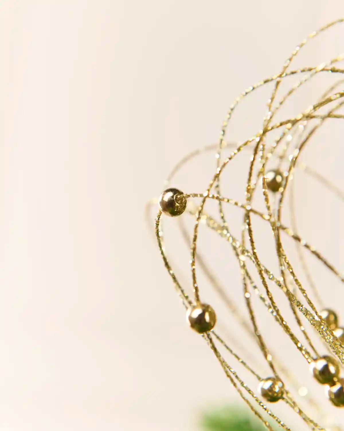 Gold Glitter Nest Christmas Tree Pick highlighting the glitter details and gold balls with a blurry cream background