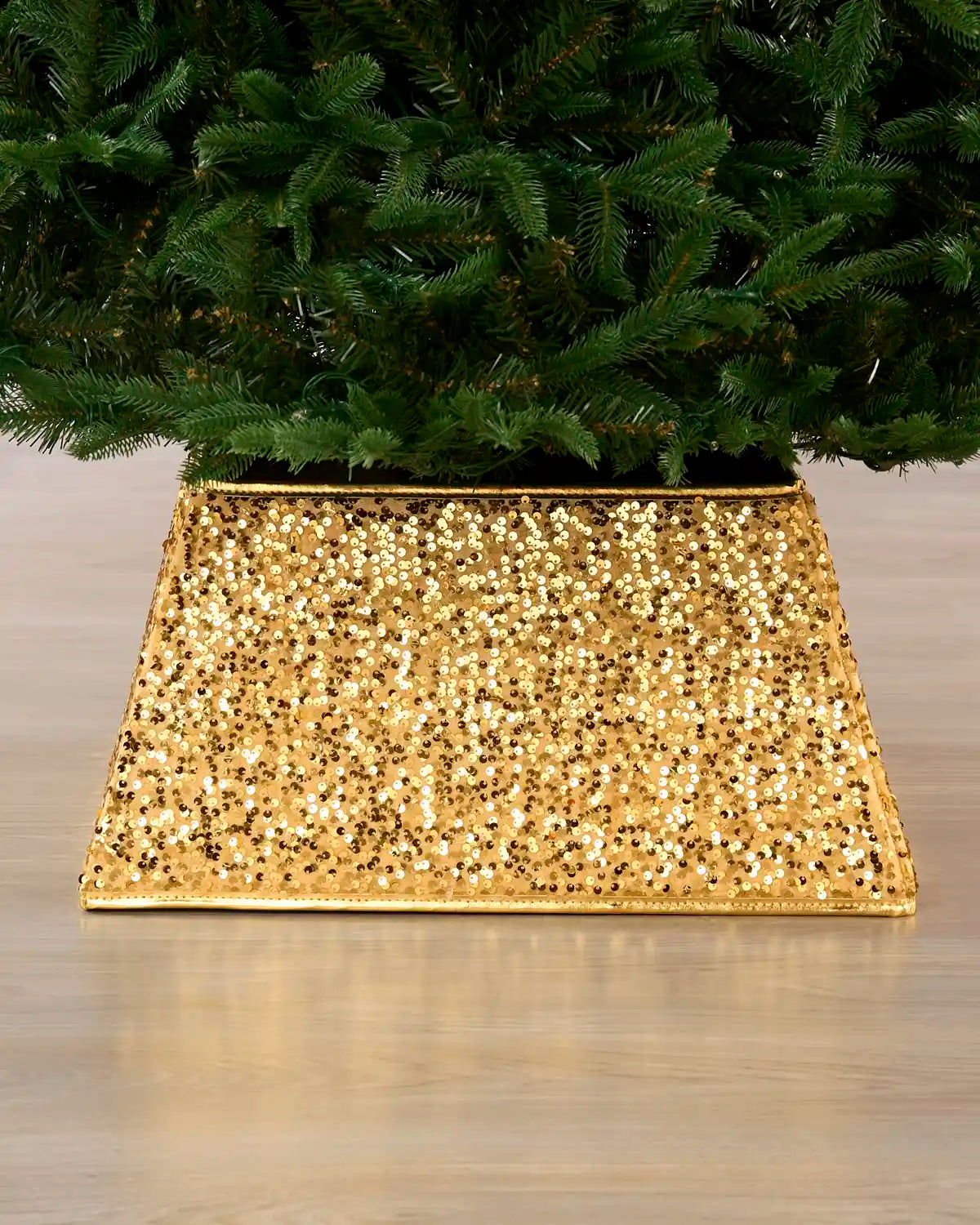 Gold Square sequin Christmas tree collar under a Christmas tree on a wooden floor 