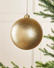 Gold glitter oversized 15cm bauble on a Christmas tree branch