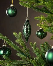 Green Christmas baubles hanging on a tree with a dark background