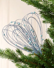 Ice Blue Glitter Nest Christmas Tree Pick placed in green Christmas tree branches with a cream background
