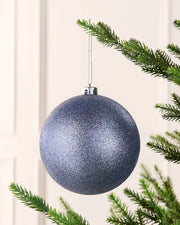 Ice blue 15 cm oversized glitter shatterproof bauble hanging on a Christmas tree with a silver cap and matching string.
