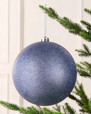 Ice blue 20 cm oversized glitter shatterproof bauble hanging on a Christmas tree with a silver cap and matching string.
