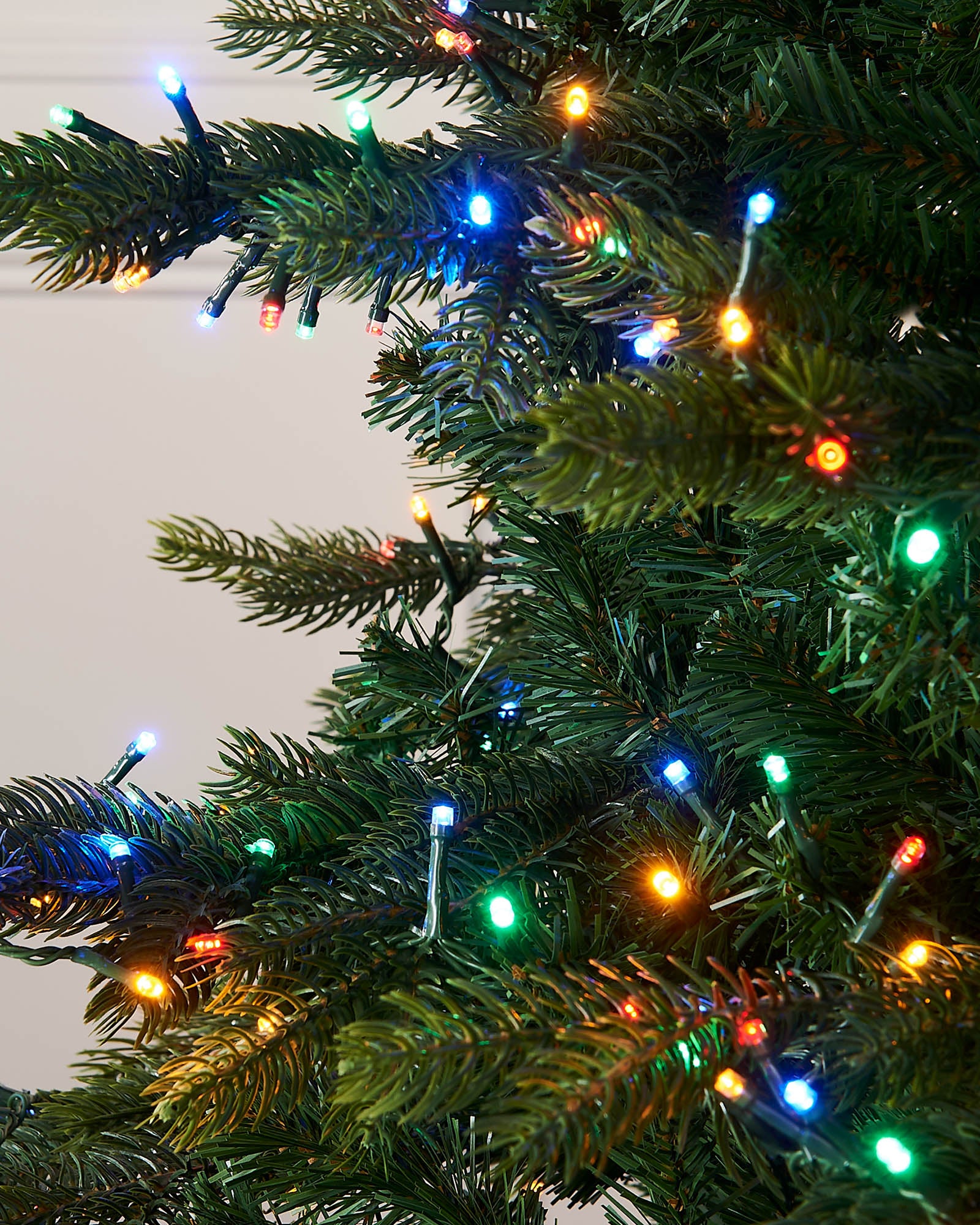 Close-up of a Christmas tree with colorful lights.