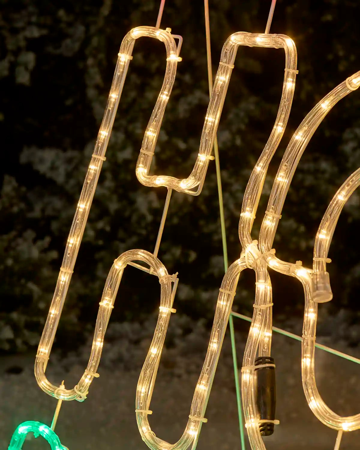 LED lighted decorative sign spelling 'Ho' in warm white, with gold lighted lettering at the top, photographed outdoors at night.
