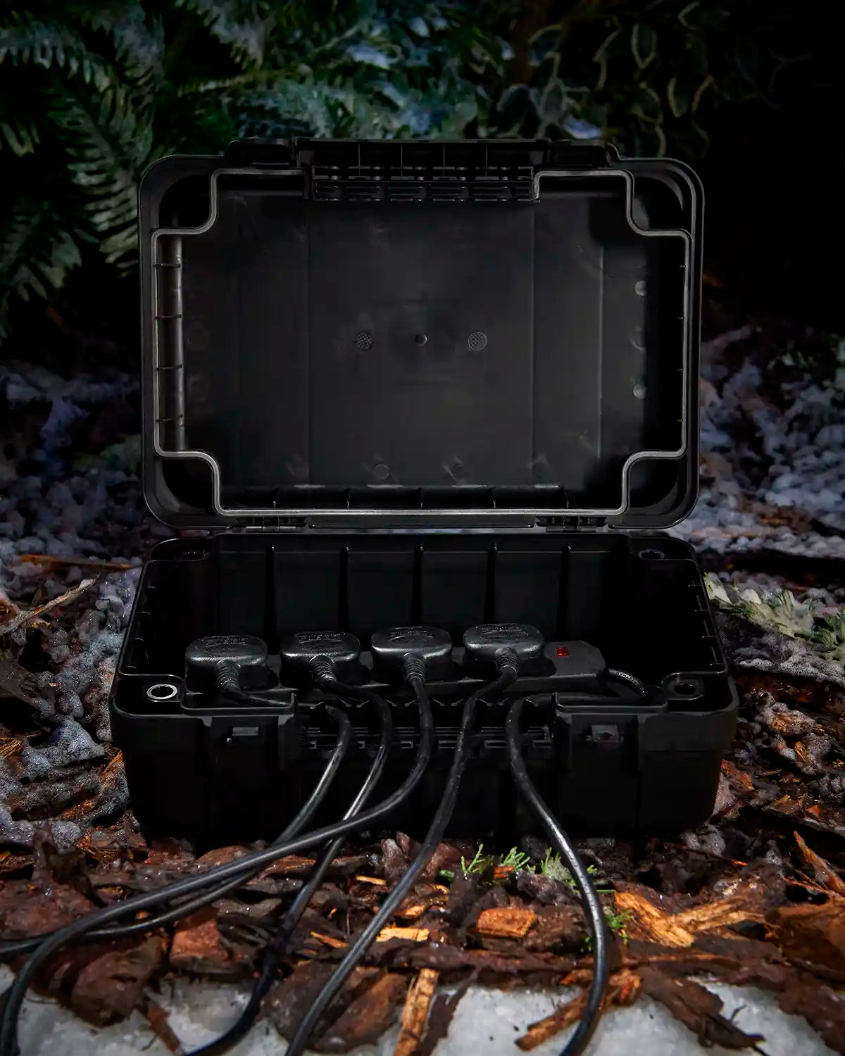 Black waterproof weather box with cables on a snowy grassy floor 