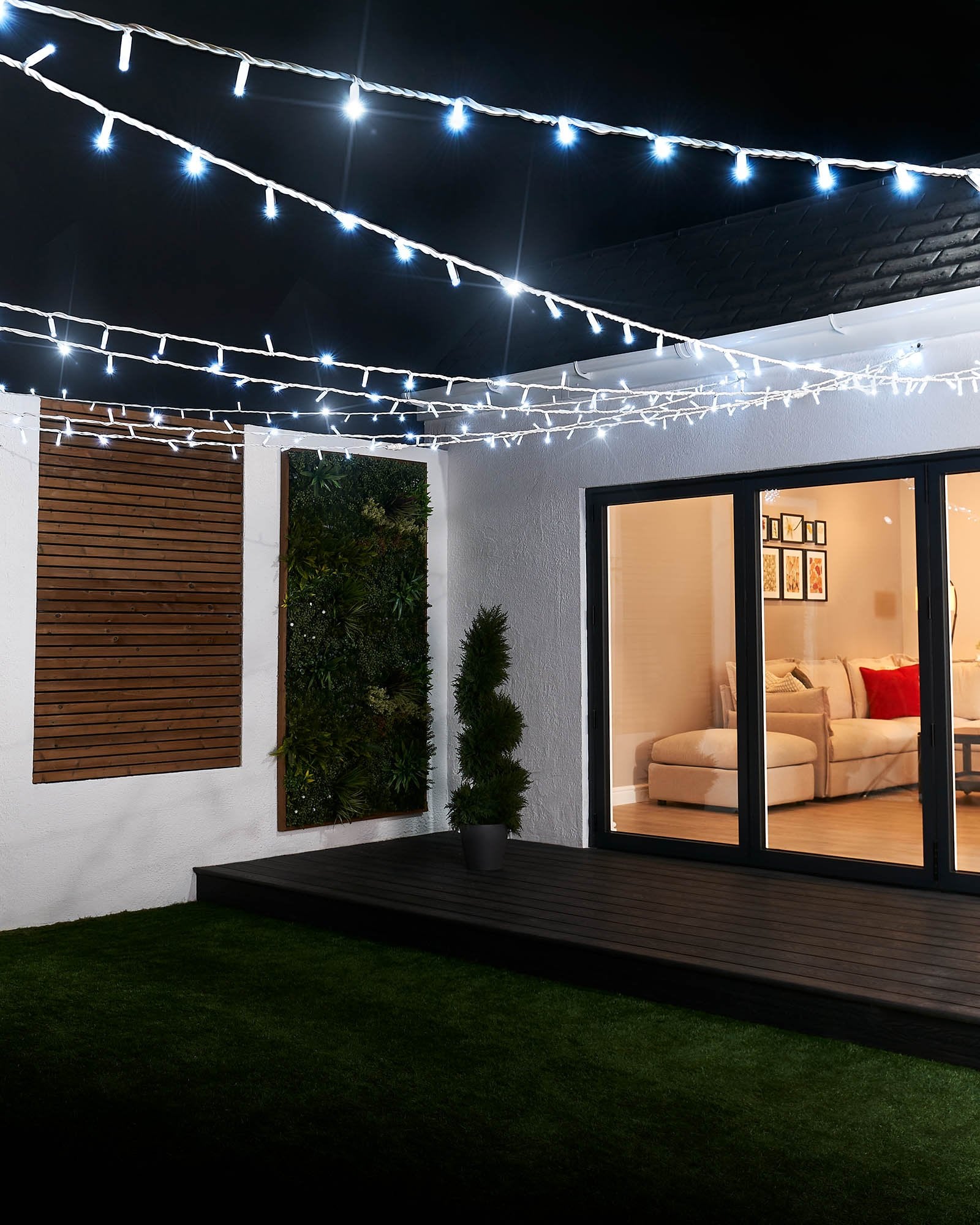 A close-up of white LED string lights with a focus on the twinkling feature, displaying the lights in an outdoor setting.