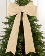 Large 140 cm latte velvet Christmas bow displayed on a lit Christmas tree with long hanging tails.

