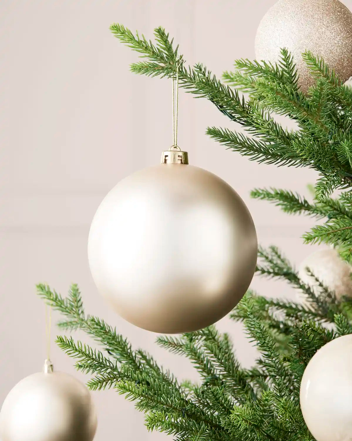 Latte 15 cm oversized matt shatterproof bauble displayed on a Christmas tree with coordinating latte baubles.
