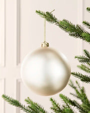 Latte 15 cm oversized matt shatterproof bauble hanging on a Christmas tree with a gold cap and matching string.
