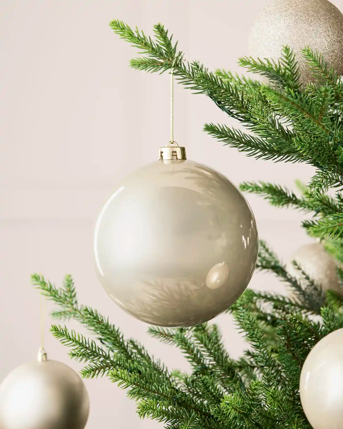 Latte 15 cm oversized shiny shatterproof bauble displayed on a Christmas tree with coordinating latte baubles.
