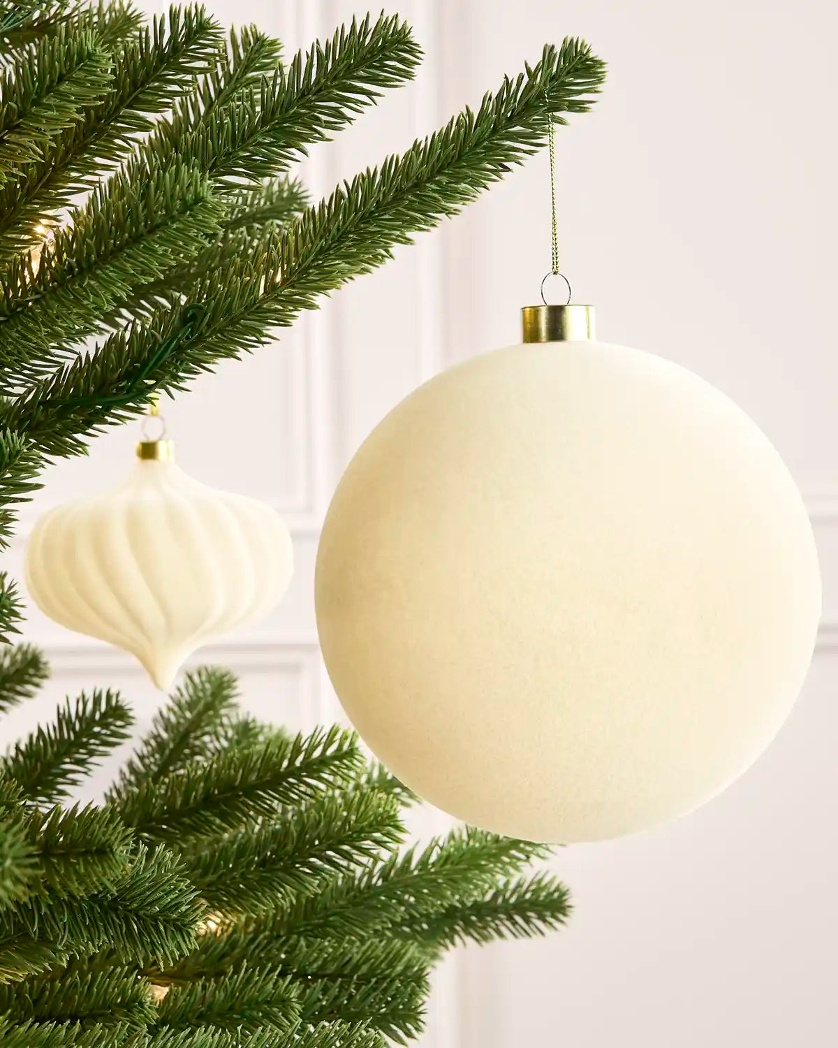 Latte 15 cm oversized velvet traditional bauble displayed on a Christmas tree with coordinating ornaments.
