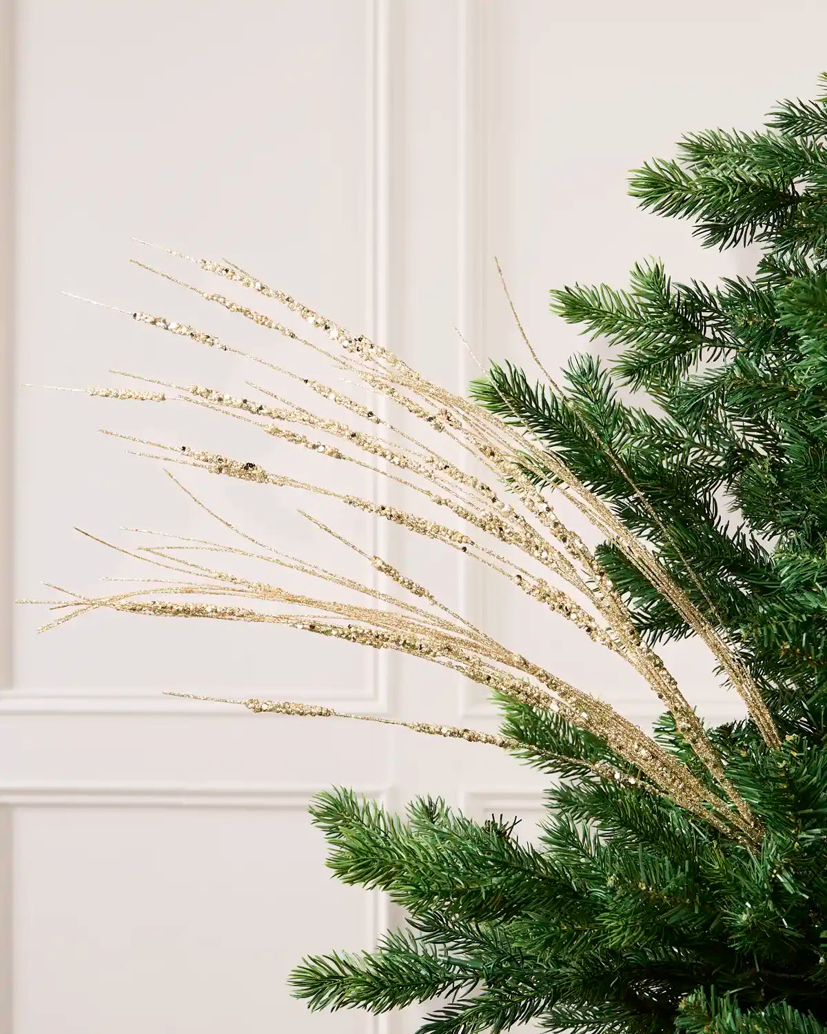 Latte Glitter Wispy Spray with long, slender glitter-covered stems arranged in a fan shape on a Christmas tree
