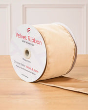 Latte Velvet Ribbon with wired edge on a wooden surface