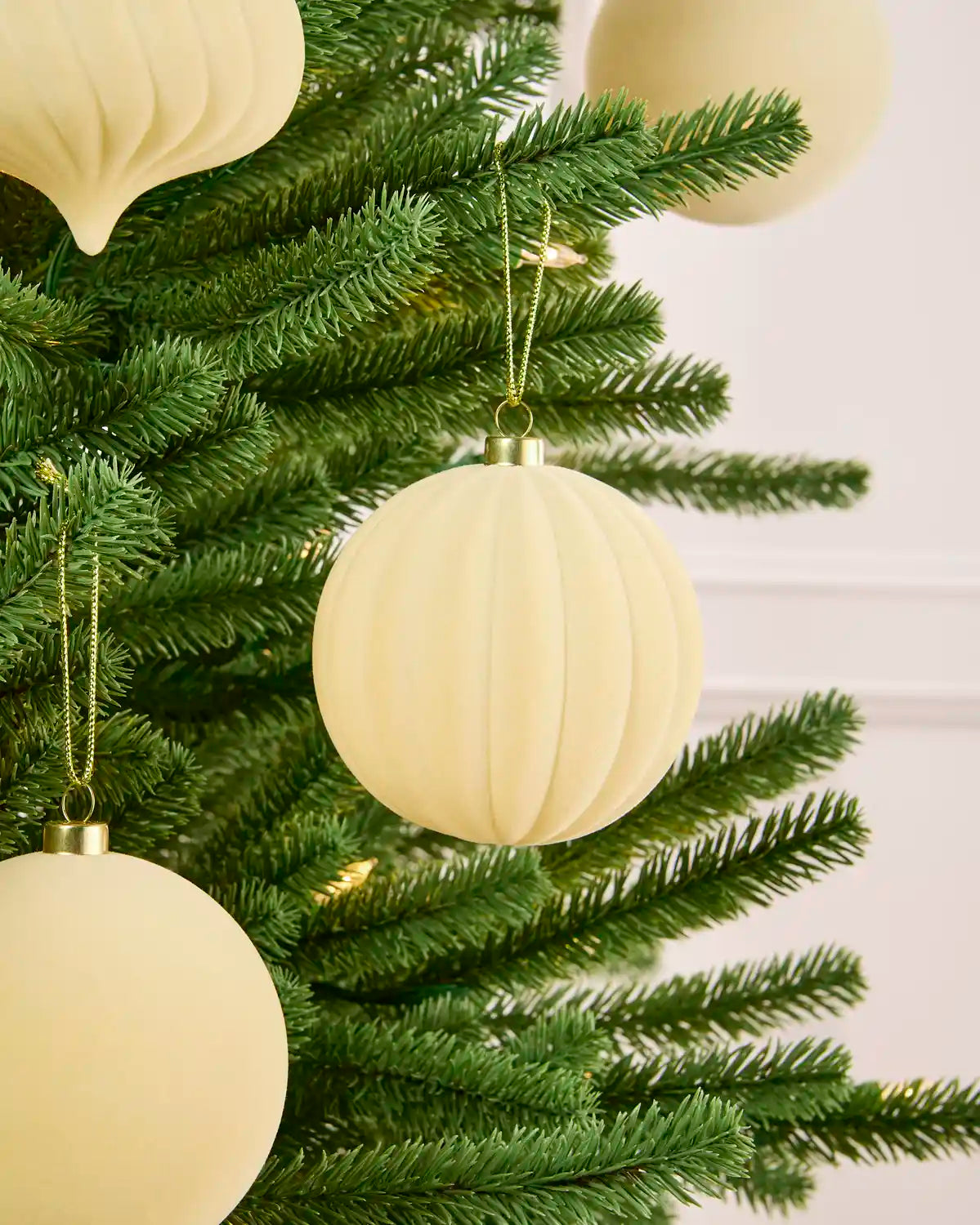 Latte velvet bauble round swirl with more shapes hanging in the background. 
