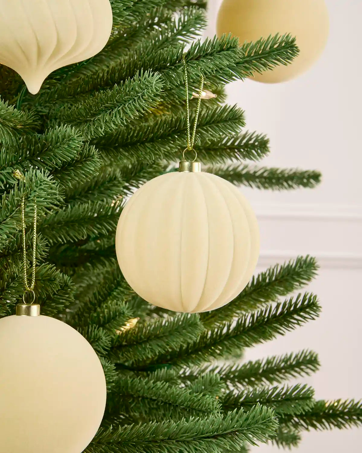 Latte velvet bauble round swirl with more shapes hanging in the background. 