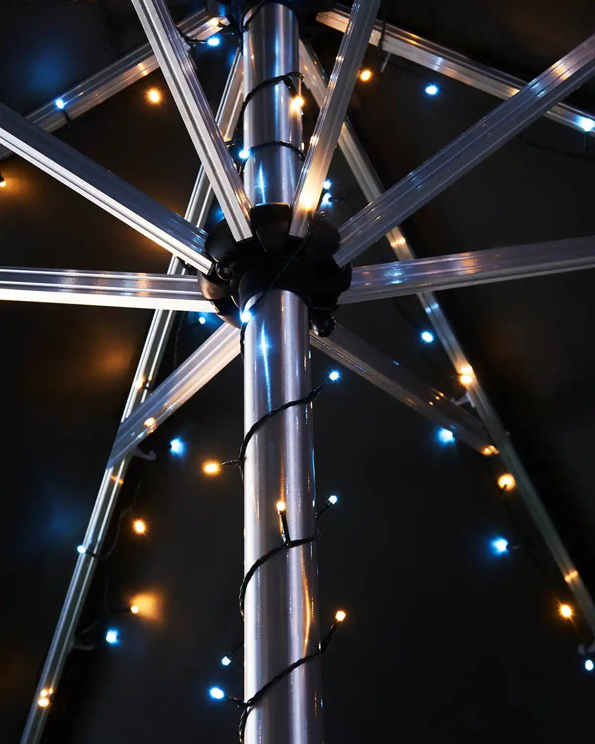 Metallic umbrella pole with warm white and ice white string lights