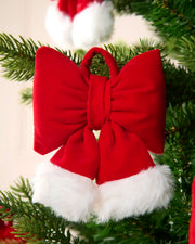 Mini Hat style bows on a Christmas tree with blurry bows in the background against a cream wall