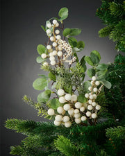 Mistletoe decorative pick on a Christmas tree against a grey background 